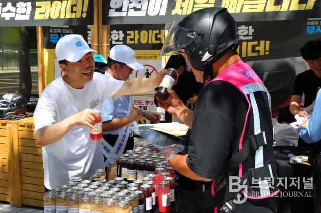 근로복지공단 박종길 이사장(왼쪽)이 지난 7월 서울 역삼역 인근에서 배달라이더들에게 시원한 음료를 나누어 주면서 고용·산재보험 거리 홍보를 진행했다.