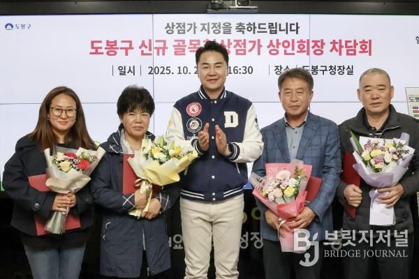 오언석 도봉구청장(가운데)과 이번에 새로 신규 지정된 골목형상점가 상인회장이 신규 지정을 기념하며 단체 사진을 찍고 있다