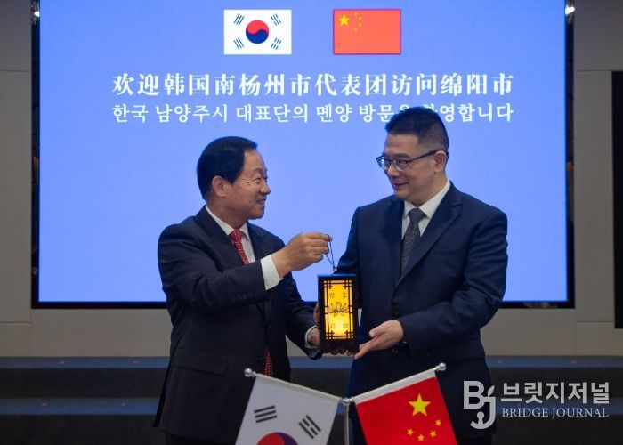 주광덕 남양주시장(좌)이 리원 몐양시장(우)에게 기념품을 전달하고 있다.