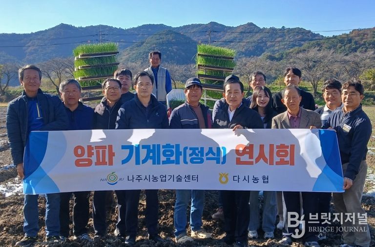 양파 기계 정식 연시회에 참가한 농업인들과 관계자들이 기념촬영을 하고 있다.