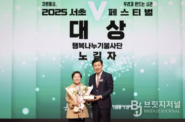 전성수 서초구청장(우측)이 ‘2025 서초V페스티벌’에서 자원봉사대상을 수상한 행복나누기봉사단 노길자 단장과 기념사진을 찍고 있다