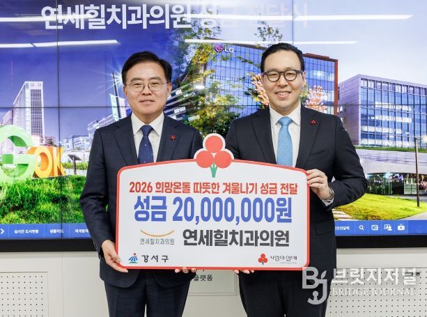 진교훈 서울 강서구청장(왼쪽)이 구청장실에서 정현준 연세힐치과의원 대표원장으로부터 이웃돕기 성금을 전달받고 기념촬영을 하고 있다.