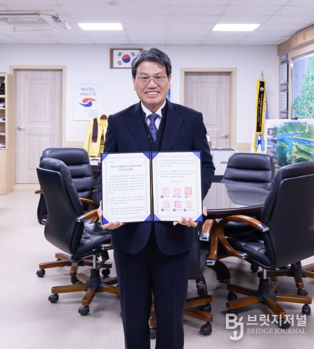 김돈곤 군수가 ‘정산동화(洞和)활력타운 조성사업’의 지역발전투자협약서를 들고 기념촬영을 진행하고 있다.