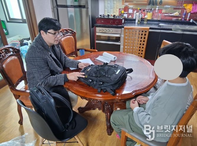 신안군 드림스타트 아동통합사례관리사가 가정 방문하여 아동에게 책가방을 전달하고 있다.