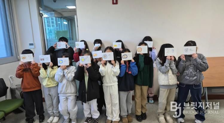 울산 초등학생들이 3일 울주도서관에서 '그림책 담은 멋 글씨 엽서' 활동을 하고 기념사진을 찍고있다