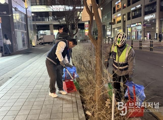 이현재 하남시장이 지난 21일 저녁 미사문화거리에서 시 소속 환경공무관들과 함께 빗자루를 들고 야간 청소 정화 활동을 펼치고 있다.
