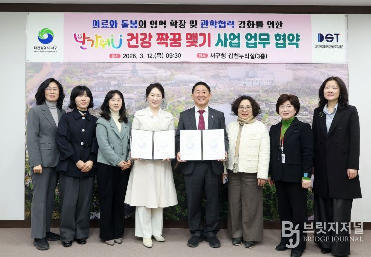 서철모 서구청장이 12일 구청 갑천누리실에서 열린 의료급여 특화사업 협약식에서 양진영 대전과기대 혁신지원사업단장과 기념 촬영을 하고 있다