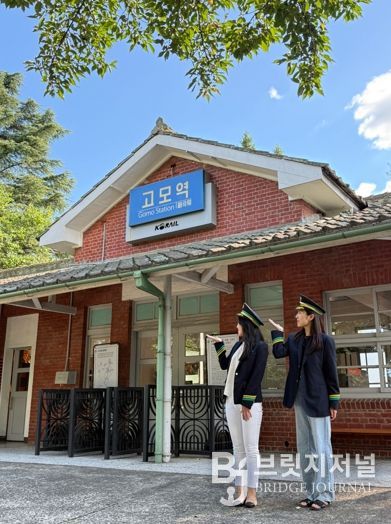 관광객들이 고모역에서 역무원 체험을 하고 있다.