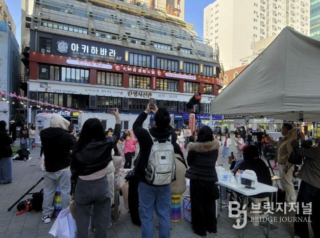 시민들이 인플루언서 크림서현과 랜덤댄스 챌린지 참여자들의 공연을 관람하고 있다.