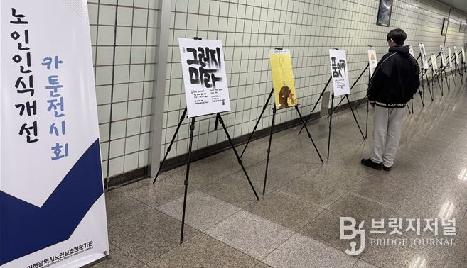 인천지하철 1호선 동춘역을 지나는 한 학생이 인천시노인보호전문기관 ‘노인인식개선 카툰전시회’ 작품을 읽고 있다.