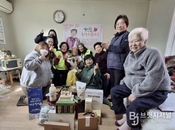 도고면 행복키움추진단 관계자들이 생신을 맞은 취약계층 독거 어르신 가정을 방문해 꽃다발과 생신 음식을 전달하며 기념촬영을 하고 있다.