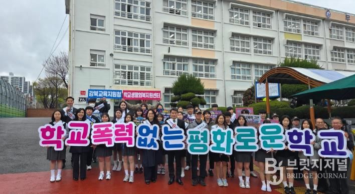 강북교육지원청 한성기 교육장과 학생들이 31일 무룡중학교에서 등굣길 학교폭력 예방 홍보활동을 하고 기념사진을 찍고있다